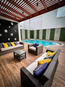 sala de estar con piscina con sofá y sillas en Casa de playa Pulpos, en Arica
