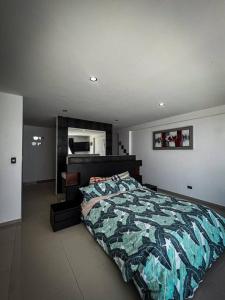 1 dormitorio con cama con colcha de camuflaje en Casa de playa Pulpos, en Arica
