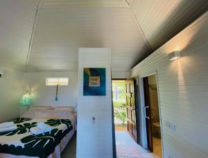 a small bedroom with a bed and a doorway at Bungalow Tiare in Uturoa