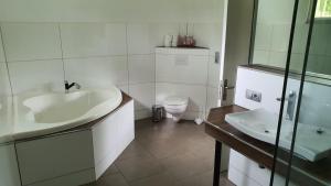 uma casa de banho branca com um lavatório e um WC em Tropische Träume em Doctor Juan Manuel Frutos
