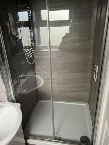a bathroom with a shower with a toilet and a sink at Modern Studio flat with free parking in Langley Marish