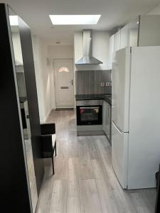 cocina con nevera blanca y fogones en Modern Studio flat with free parking, en Langley Marish