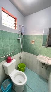 ein Bad mit einem WC und einem Waschbecken in der Unterkunft Manalo's Lodge and Restaurant in Puerto Galera