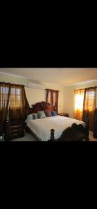 a bedroom with a bed with a wooden frame and windows at Jlp in San Francisco de Macorís