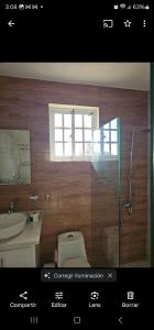 a bathroom with a toilet and a sink and a window at Jlp in San Francisco de Macorís
