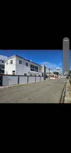 an empty street in front of a white building at Jlp in San Francisco de Macorís