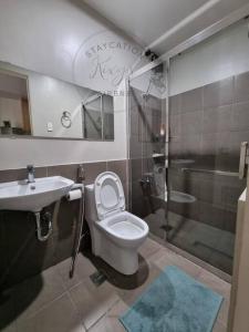 e bagno con servizi igienici, lavandino e doccia. di Staycation @ Crosswinds Tagaytay a Tagaytay