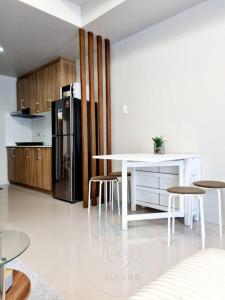 una cucina con tavolo bianco e frigorifero nero di Staycation @ Crosswinds Tagaytay a Tagaytay