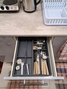 a drawer in a cabinet filled with cooking utensils at Flat near the Vyšehrad Castle in Prague