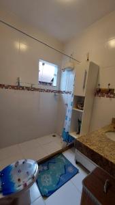 uma pequena casa de banho com um chuveiro e um lavatório. em Casa Azul, Long Beach Unamar Cabo Frio em Tamoios