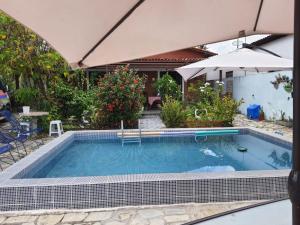 uma piscina interior com um guarda-sol e anopheemetery em Casa em Ponto de Lucena em Lucena