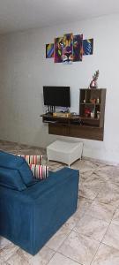 sala de estar con sofá azul y escritorio en Casa OliMar fins de semana, en Bertioga