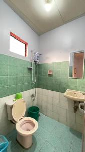 ein Bad mit einem WC und einem Waschbecken in der Unterkunft Manalo's Lodge and Restaurant in Puerto Galera