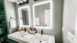 a bathroom with a white sink and two mirrors at Private Modern Luxury Suite in Historic Stone Home in Washington