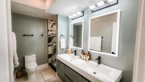 a bathroom with a sink and a toilet and a mirror at Private Modern Luxury Suite in Historic Stone Home in Washington