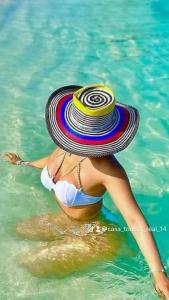 Una mujer en el agua con un sombrero en la cabeza en Casa Torices Real 12, en Cartagena de Indias