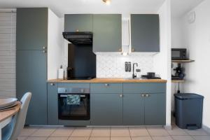 a kitchen with blue cabinets and a sink at Le Cookie - 4 pers' - 2 lits - Gare 50m - Parking in Woippy