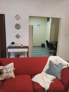 un sofá rojo con almohadas en la sala de estar en Departamento en Posadas, en Posadas