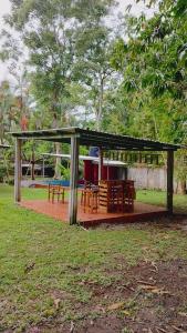 a shelter with tables and chairs in a park at Perla del rio tulian in Omoa