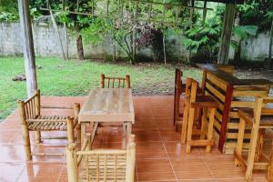 una mesa de madera y sillas en un patio en Perla del rio tulian, en Omoa