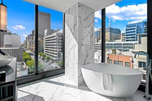 a bathroom with a tub and a view of a city at Sofitel Adelaide in Adelaide