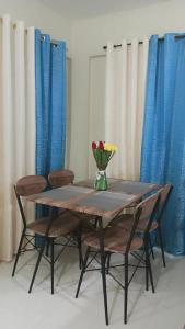 une table avec des chaises et un vase de fleurs. dans l'établissement Pagadian Staycation in Camella 1, à Pagadian