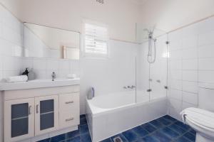 a bathroom with a tub and a sink and a toilet at WINCH9 - Seaside Serenity in Sydney