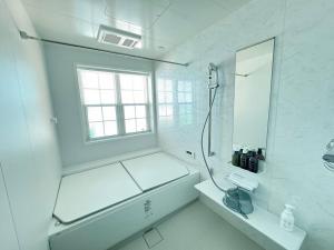 a white bathroom with a shower and a sink at Queen Anne Style Luxury Vacation Villa in Miyota +21 photos