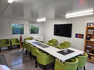 a conference room with a table and green chairs at Motell Lier in Lier