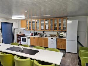 a kitchen with a table and green chairs at Motell Lier in Lier