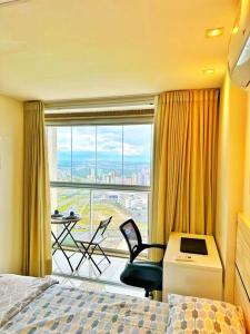 a hotel room with a bed and a large window at Aconchego dentro do Shopping em Brasília in Brasilia