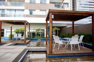- un kiosque avec une table et des chaises sur la terrasse dans l'établissement Maravilhoso Apartamento em Brasília DF, à Brasilia