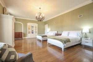 a bedroom with two beds and a chandelier at Wood Manor Guest House in Tuscaloosa