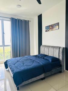 a bedroom with a bed with blue sheets and a window at Meridin Bayvue Sea View Homestay by JP in Masai