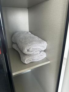 una pila de toallas sentadas en un estante en Meridin Bayvue Sea View Homestay by JP en Masai