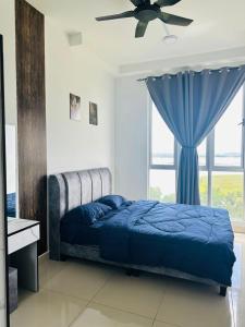 a bedroom with a blue bed and a window at Meridin Bayvue Sea View Homestay by JP in Masai