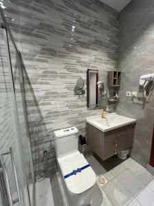 a bathroom with a toilet and a sink and a shower at شقة فندقية راقيه ثلاث غرف نوم in Jeddah