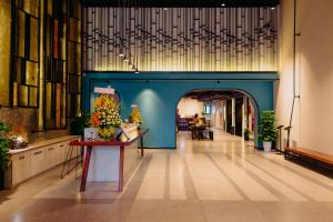 Em Oi Boutique Hotel في نها ترانغ: ممر بحائط ازرق وطاولة بها ورد
