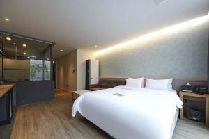 a bedroom with a large white bed and a kitchen at No25 Hotel Yangpyeong Seojong in Yangpyeong