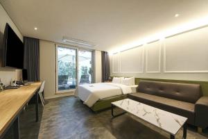 una camera d'albergo con letto e divano di No25 Hotel Yangpyeong Seojong a Yangpyeong