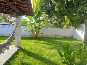 a yard with a hammock in the grass at Casa confortável em Estancia in Estância +12 photos