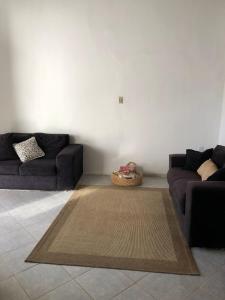 a living room with two couches and a rug at Casa confortável em Estancia in Estância