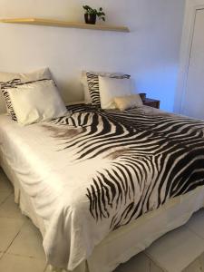 Una cama con una manta de cebra. en Casa confortável em Estancia en Estância