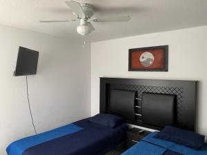 - une chambre avec 2 lits et un ventilateur de plafond dans l'établissement Casa de Bryanna, à San Luis Potosí