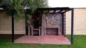 a picnic shelter with a bench in front of a stone wall at Casa de Bryanna in San Luis Potosí