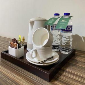 uma bandeja com comodidades para preparar café e 2 garrafas de água em Travellers Hotel Phinisi em Makassar