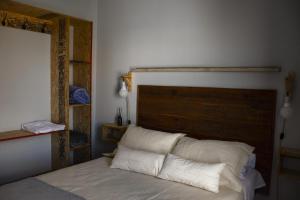 sypialnia z łóżkiem z drewnianym zagłówkiem w obiekcie Hostel Las Pibas w mieście Sarmiento