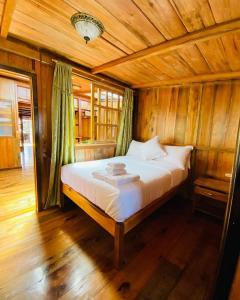 a bedroom with a bed in a wooden room at Guayabo Hostal Spa in Mindo