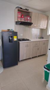 a kitchen with a black refrigerator and wooden cabinets at Apartamento amoblado (Coveñas) in Coveñas