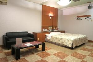 um quarto com uma cama, uma cadeira e uma mesa em Hotel Silk no Mori (Adult Only) em Tosu